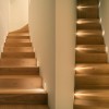 Mise en lumière à l'horizontale sur escalier bois encastré mural LED Raggio collerette blanche Viabizzuno - Valente Design