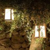 Lanterne solaire TECKA H25 cm Teck verre dépoli Les Jardins Valente Design allumée suspendue dans arbre