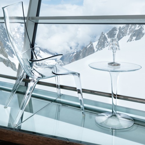 Table basse Tip Top de Kartell cristal avec lampe Battery sans fil cristal et fauteuil Uncle Jim cristal sur fond de montagne