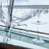 Table basse Tip Top de Kartell cristal avec lampe Battery sans fil cristal et fauteuil Uncle Jim cristal sur fond de montagne