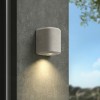 Applique d'extérieur Brixham Wall Single d'Astro Lighting finition béton gris allumée sur un mur extérieur de jour