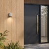 Applique d'extérieur Brixham Wall Single d'Astro Lighting finition béton gris allumée dehors à côté d'une porte de jour