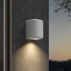Applique d'extérieur Brixham Wall Single d'Astro Lighting finition béton blanc allumée sur un mur extérieur de nuit