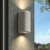 Applique d'extérieur Brixham Wall Twin d'Astro Lighting finition béton gris allumée sur un mur extérieur de jour