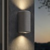 Applique d'extérieur Brixham Wall Twin d'Astro Lighting finition béton gris allumée sur un mur extérieur de nuit
