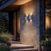 2 appliques d'extérieur Brixham Wall Twin d'Astro Lighting finition béton blanc allumées sur un mur extérieur de nuit