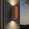 Applique d'extérieur Brixham Wall Twin d'Astro Lighting finition béton terracotta allumée sur un mur extérieur de nuit